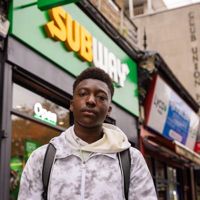 Bite Back activist Timi stands in front of the fast food chain Subway