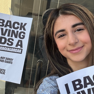 Bite Back activist Prusha takes a selfie with our poster which reads I back giving kids a commercial break sorry not sorry junk food giants