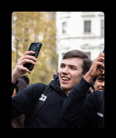 A young man is holding his phone up to take a picture of something