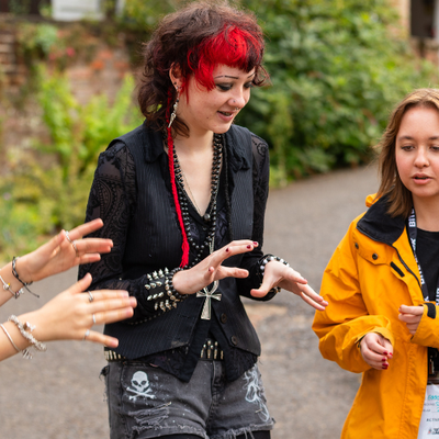 Three young people are playing a game with their hands, similar to rock paper scissors
