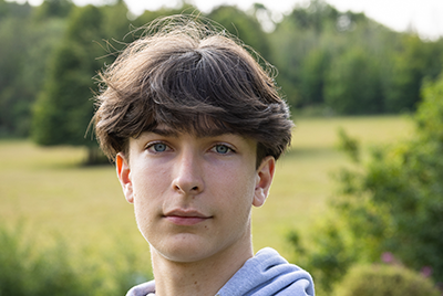 A young white man with cropped brown hair is looking into the camera with a powerful expression.