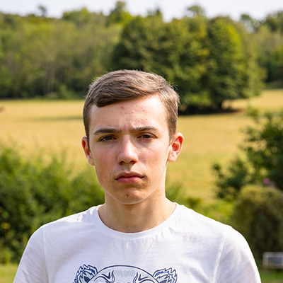 A young white man with short hair is gazing sternly into the camera.